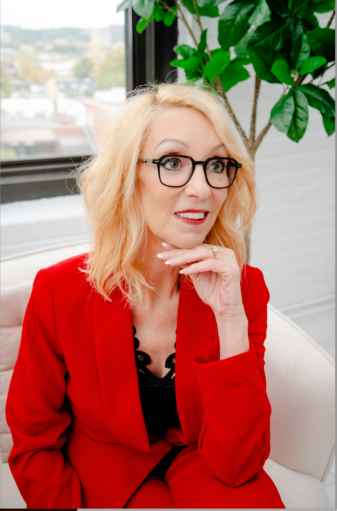 Portrait de Lucie Payant, thérapeute en relation d’aide, souriante, en veston rouge